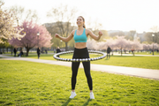 Woman using weighted magnetic hula hoop outdoors