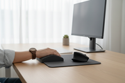 Hand resting on memory foam wrist support pad at modern desk